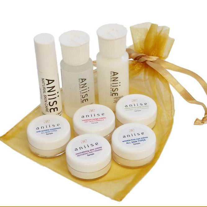 Aniise Skin Care Sample Pack with seven product jars and bottles in a gold pouch, ideal for testing best-selling products.