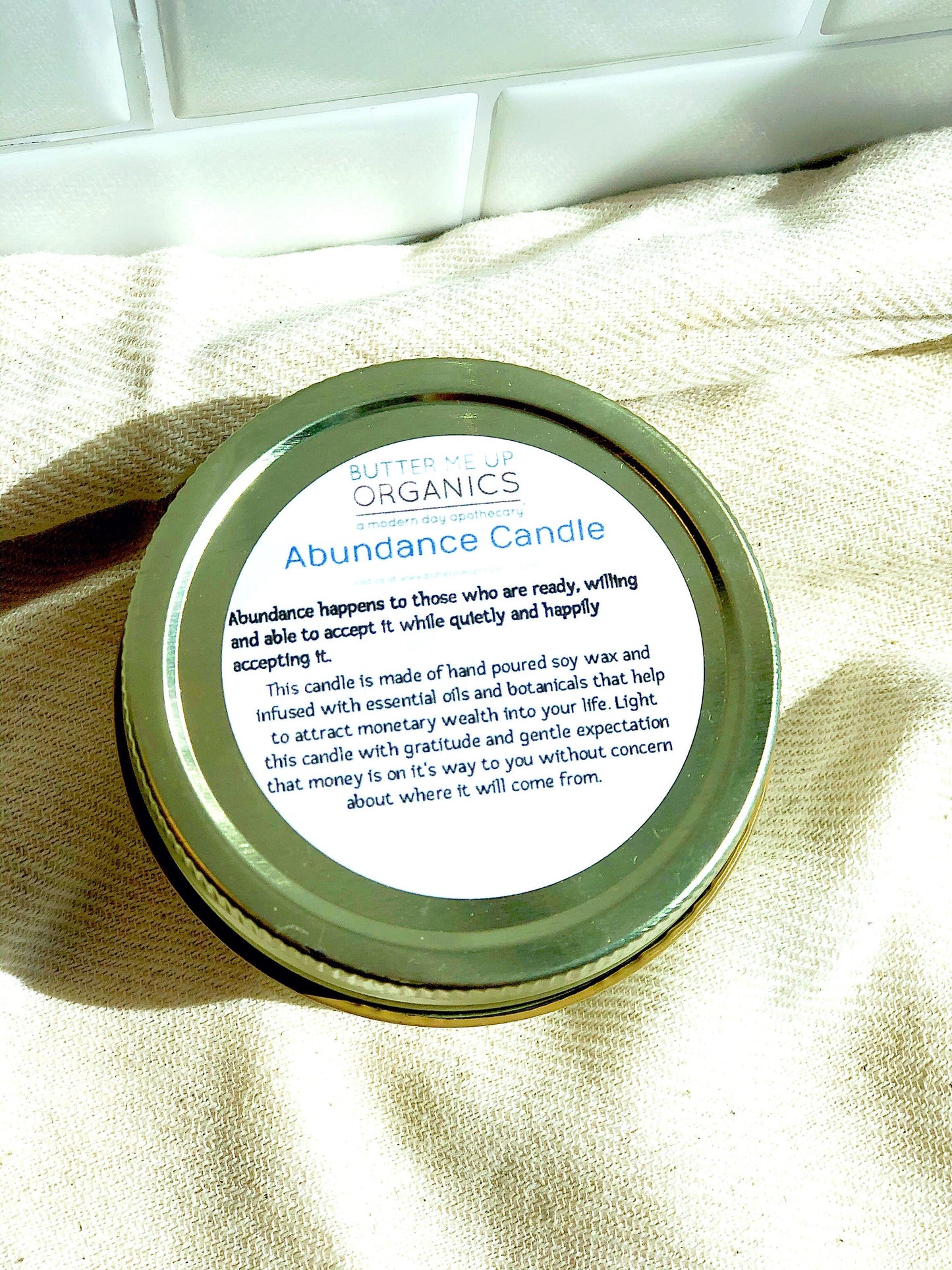 Abundance Ritual Candle in a jar with a label, made from natural soy wax, designed for attracting monetary abundance.