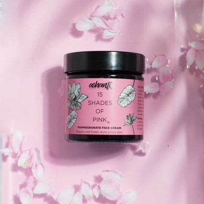 15 Shades of Pink Pomegranate Face Cream jar surrounded by soft pink petals for radiant skin nourishment.